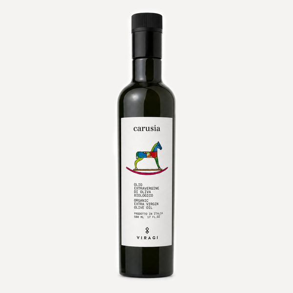 A dark glass bottle of Viragi's Carusia organic extra virgin olive oil, featuring a white label with a colorful rocking horse logo and a black cap, set against a light gray background.