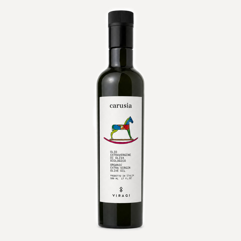 A dark glass bottle of Viragi's Carusia organic extra virgin olive oil, featuring a white label with a colorful rocking horse logo and a black cap, set against a light gray background.