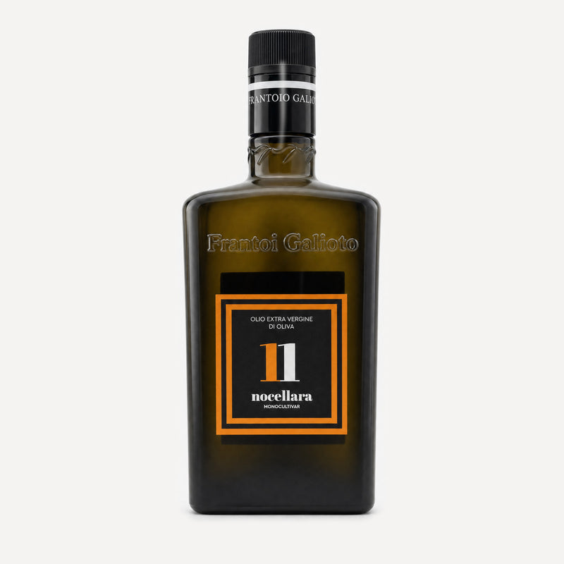 A dark olive-green glass bottle of Frantoio Galioto Nocellara N*11 olive oil, featuring a black cap and a black label with orange borders and white text.