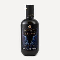 A bottle of Tenuta Cavasecca's Siracusana Zaituna Extra Virgin Olive Oil on a light gray background. The bottle is dark glass with a black cap and a black label featuring gold lettering and blue illustrations.